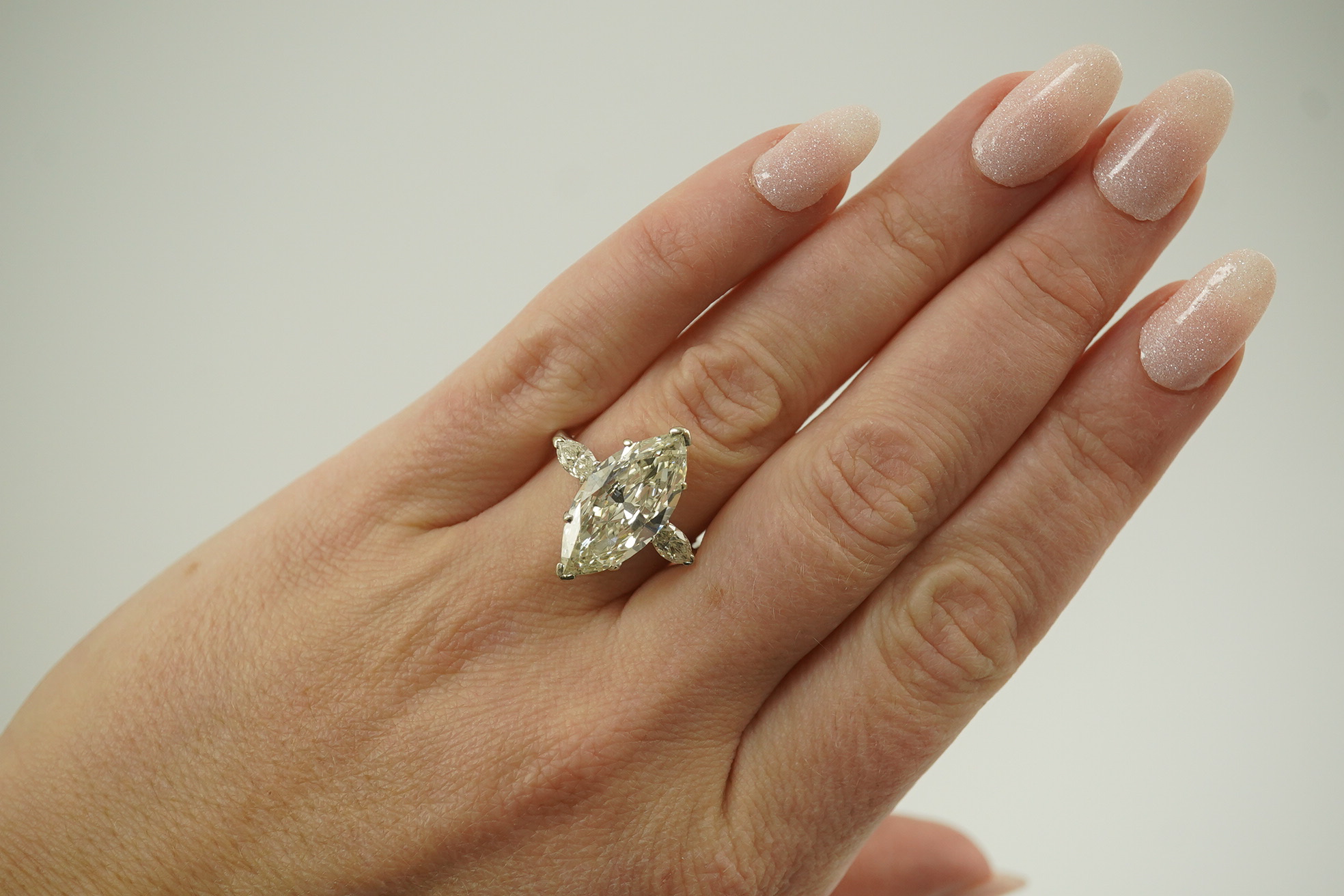 A modern 18ct white gold and single stone marquise cut diamond set ring, with two stone marquise cut diamond set shoulders